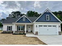 Charming one-story home featuring board and batten siding, stone accents, and a two-car garage at 1000 Peedin Rd, Selma, NC 27576