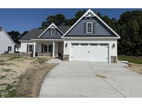 Charming two-story home with a two-car garage and stone accents and covered front porch at 1000 Peedin Rd, Selma, NC 27576