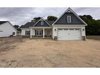 Charming single-story home with a two-car garage, neutral siding, and complementary blue shudders at 1000 Peedin Rd, Selma, NC 27576