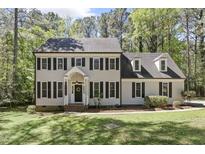 Charming two-story home featuring classic architectural design and a well-manicured front yard with mature trees at 1013 Whitney Springs Ct, Holly Springs, NC 27540