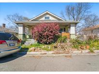Charming home featuring a covered porch adorned with a beautiful pink shrub in the front yard at 1207 Wall St, Durham, NC 27701
