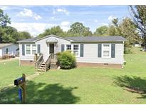 Charming single-story home with a well-maintained lawn and inviting front entrance at 125 S State St, Haw River, NC 27258