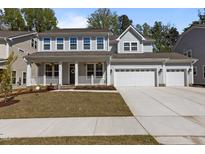 Charming two-story home with a manicured front yard and attached three-car garage at 1265 Meadow Queen Ln, Apex, NC 27502