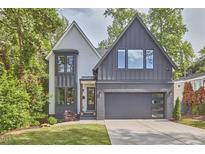 Charming two-story home featuring a modern gray and white exterior, well-manicured lawn, and attached garage at 1336 Courtland Dr, Raleigh, NC 27604