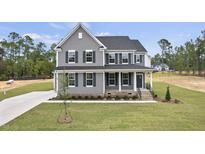 Charming two-story home with gray siding, black shutters, and inviting front porch, landscaped with a well-maintained lawn at 134 Ivy Ridge Rd, Chapel Hill, NC 27516
