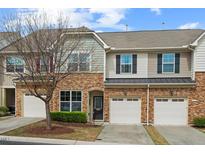 Charming townhome with a stone facade, one-car garage and manicured landscaping at 15 Plumas Drive Dr, Durham, NC 27705