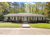 Charming single-story home boasts a well-maintained lawn, mature trees, and inviting front porch at 2225 Whitley Dr, Durham, NC 27707