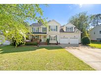 Charming two-story home featuring a landscaped yard, front porch, and two-car garage at 226 Marquis Dr, Cameron, NC 28326