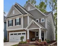 Charming two-story home with stone accents, neutral siding, attached garage, and covered front porch at 2283 Grants Pass Sta, Apex, NC 27502