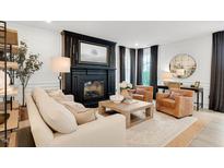 Bright living room features a fireplace, neutral tones, and comfortable seating at 2283 Grants Pass Sta, Apex, NC 27502