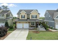 Charming two-story home with a welcoming front porch, manicured lawn, and two-car garage at 233 Pointe Park Cir, Holly Springs, NC 27540