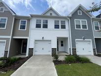 Charming townhome with a single-car garage, inviting entryway, and tastefully landscaped front yard at 236 Paramount Dr, Smithfield, NC 27577
