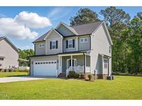 Charming two-story home with a manicured lawn, attached garage, and inviting front porch at 263 Annali Way, Wendell, NC 27591