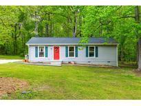Charming single-story home featuring a bright red front door and well-maintained green lawn at 329 Cartwright Cir, Wendell, NC 27591