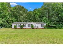 Charming single-story home with a well-manicured lawn and mature trees at 4047 Mistletoe Dr, Burlington, NC 27217