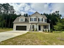 Charming two-story home featuring a two-car garage, well-manicured lawn, and classic design elements at 437 Earnest Way, Kenly, NC 27542