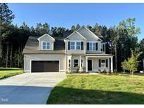 Charming two-story home with a two-car garage and landscaped yard with a treeline at 437 Earnest Way, Kenly, NC 27542