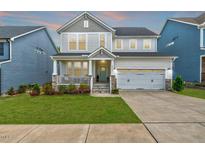 Charming two-story home with a well-manicured lawn, a covered porch, and an attached two-car garage at 4408 Walker Hallow St, Raleigh, NC 27616