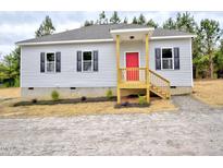 Charming single-story home featuring gray siding, black shutters, and a bright red front door at 58 S Grace Way, Henderson, NC 27537
