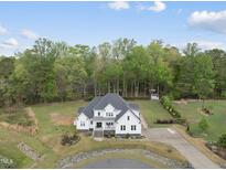 Stunning white farmhouse with a meticulously landscaped yard and circular driveway at 6024 Lunenburg Dr, Raleigh, NC 27603