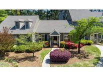 Charming gray two-story home boasts a beautifully landscaped front yard with vibrant azaleas and lush greenery at 918 Albany Ct, Raleigh, NC 27615
