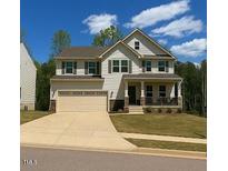 Charming two-story home with a manicured lawn and an attached two-car garage at 1216 Edgemoore Trl, Wake Forest, NC 27587
