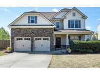 Charming two-story home featuring a two-car garage, stone accents, and manicured landscaping at 138 Horizon Trl, Garner, NC 27529
