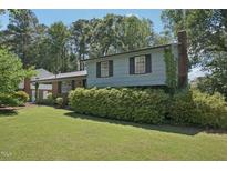 Charming two-story home featuring a brick and siding exterior, lush landscaping, and a well-maintained lawn at 1636 Cone Ave, Apex, NC 27502