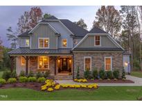 Beautiful stone and shingle home featuring manicured lawn and attractive front porch at 2113 Mt Sinai Rd, Chapel Hill, NC 27514