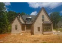 Newly constructed brick home featuring a prominent roofline and traditional architectural details at 2305 Ballywater Lea Way, Wake Forest, NC 27587