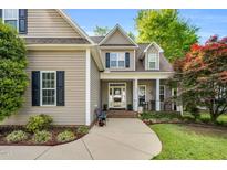 Inviting front entrance featuring a covered porch, well-manicured landscaping, and traditional architectural details at 262 Windgate Dr, Clayton, NC 27527
