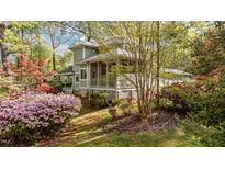 Charming home featuring a screened porch, lush landscaping, and a serene outdoor setting at 373 Sagamore Dr, Louisburg, NC 27549