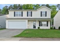 Charming two-story home with a well-maintained lawn and attached two-car garage at 413 Weeping Willow Dr, Durham, NC 27704