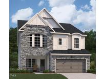 Charming two-story home showcasing a stone facade, arched windows, and a two-car garage at 4311 Emeline Way # 13, Fuquay Varina, NC 27526