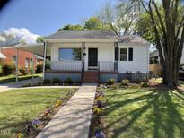 Charming home with a landscaped front yard and a walkway lined with colorful flowers at 509 Coleman St, Raleigh, NC 27610