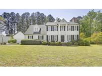 Beautiful two-story home with black shutters, landscaped front yard, and a charming gable-roof garage at 5301 Night Heron Dr, Wake Forest, NC 27587