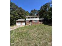 Charming two-story home with a brick exterior and a two-car garage, surrounded by mature trees at 683 Osgood Rd, Sanford, NC 27330