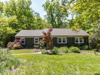Charming single-story home featuring a well-maintained lawn and lush landscaping at 713 Macon Pl, Raleigh, NC 27609