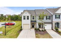 Charming townhome featuring a single-car garage, neutral siding, and a well-maintained front lawn at 72 S Grey Abbey Dr, Clayton, NC 27527