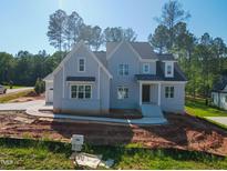 Charming two-story home featuring light grey brick, black accents, and large windows providing lots of natural light at 7301 Wexford Woods Ln, Wake Forest, NC 27587