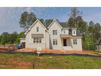 New construction two-story home with light gray brick, white trim, and black roof at 7301 Wexford Woods Ln, Wake Forest, NC 27587