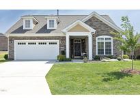 Charming single-Gathering home featuring a stone facade, dormer windows, and a well-manicured lawn at 769 Ashley Woods Dr, Gibsonville, NC 27249