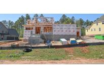 New construction showcases block foundation, Tyvek wrap, wood frame and building progress amidst a verdant landscape at 7961 Wexford Waters Ln, Wake Forest, NC 27587