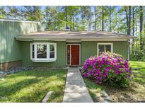 Charming home featuring a well maintained front yard, bay window, and a vibrant red front door at 8 Bluebell Ct, Durham, NC 27713
