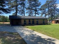 Charming one-story brick home with a well-manicured lawn and long driveway at 83 Brentwood Dr, Selma, NC 27576