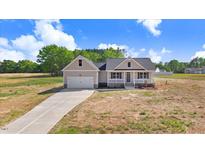 Charming single-Gathering home boasts a manicured lawn and attached two-car garage at 9391 Turkey Way, Middlesex, NC 27557