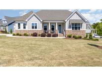 Charming home featuring stone accents, a covered front porch, and well-manicured landscaping at 101 Becklow Ridge Lane Ln, Holly Springs, NC 27540