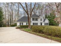 Beautiful white home featuring black shutters, dark roof, and a circular driveway at 108 Monarch Way, Cary, NC 27518