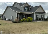 Charming two-story home with gray siding, covered porch, and manicured front lawn at 116 Polenta Fields Dr, Smithfield, NC 27577