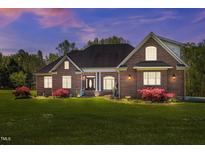 Charming brick home featuring a well-manicured lawn and a welcoming entrance with stately columns at 1174 Robertson Rd, Roxboro, NC 27574